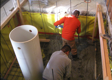 Pouring concrete for the elevator pit floor.