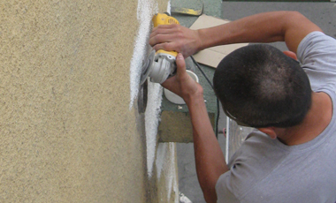A worker cleans the area around a roof drain.