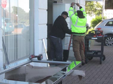 A crew replaces one of the mirror finish doors that had been mismanufactured.